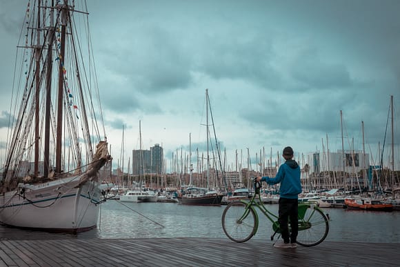 Chico con bicicleta en el Puerto de Barcelona